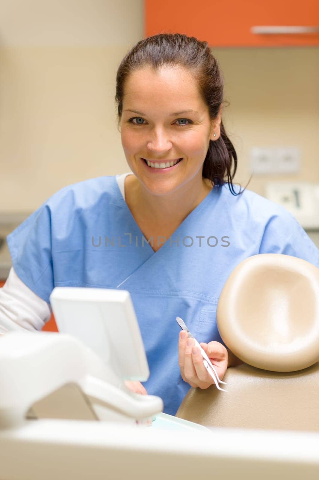 Smiling dentist woman prepare dental tools at modern surgery office