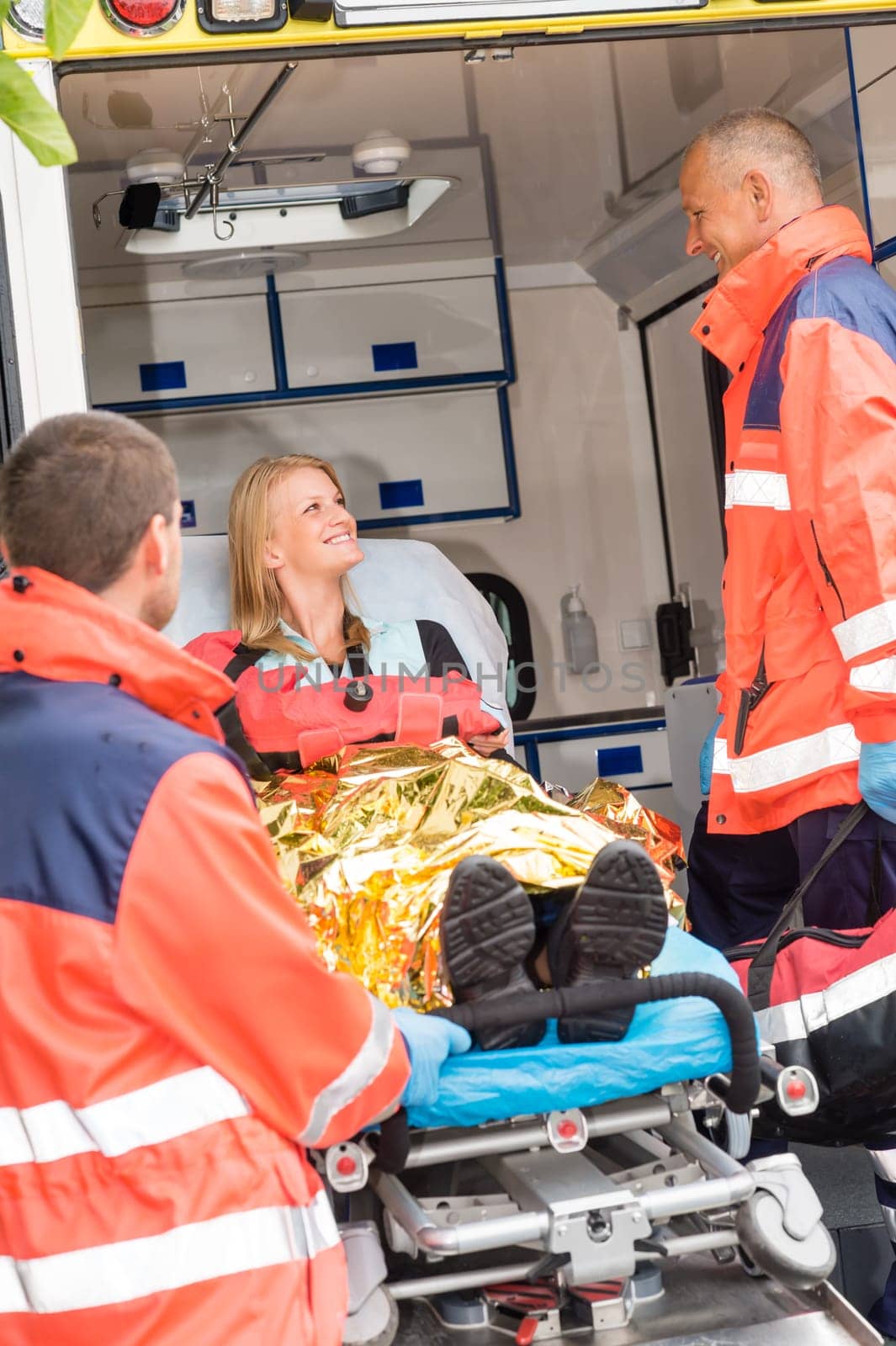 Emergency paramedics with injured woman in ambulance on stretcher