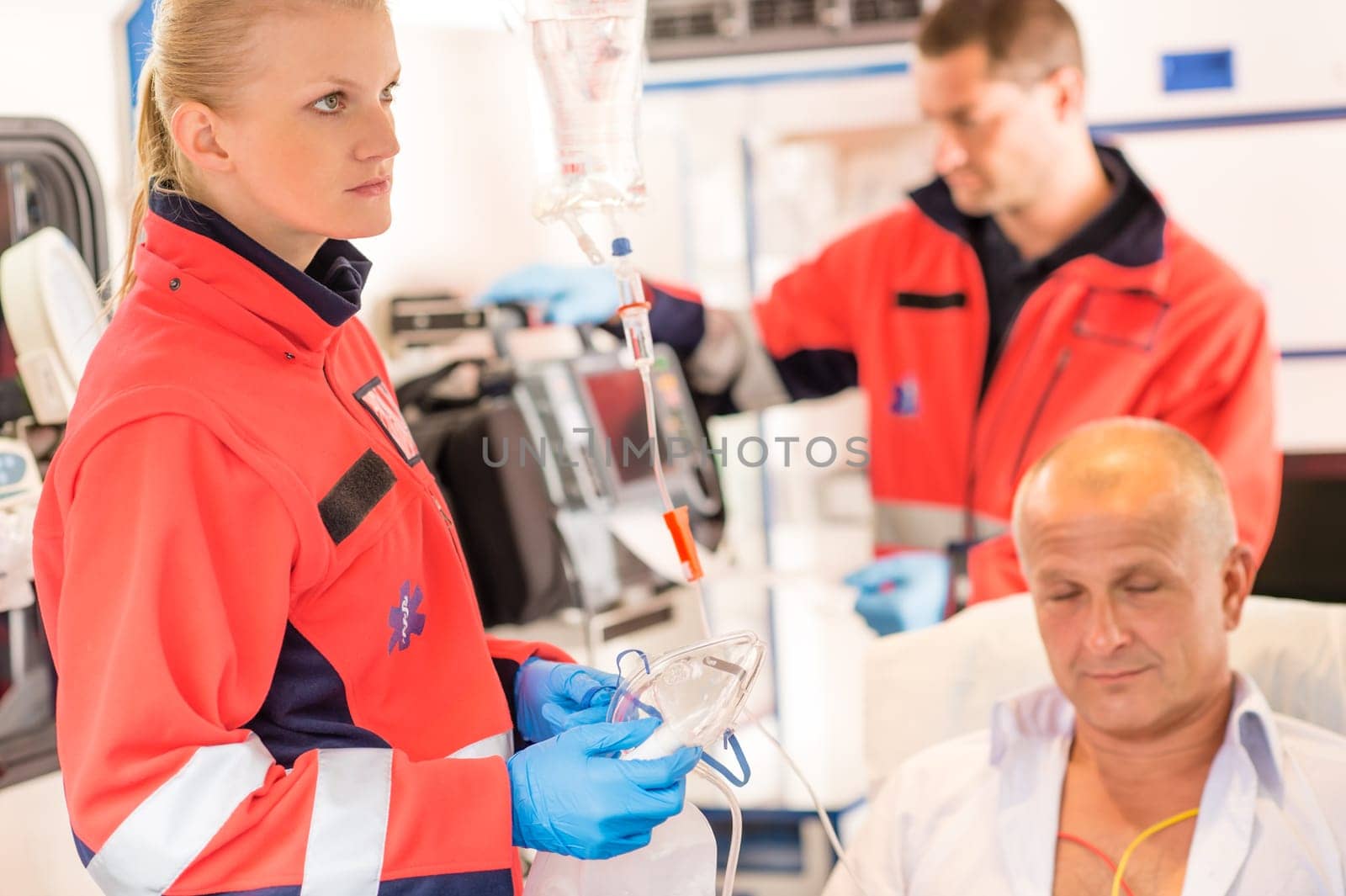 Paramedics in ambulance with patient heart attack treatment emergency sick