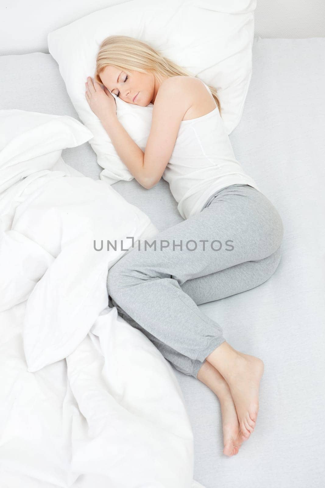 Young beautiful woman sleeping in bed at home