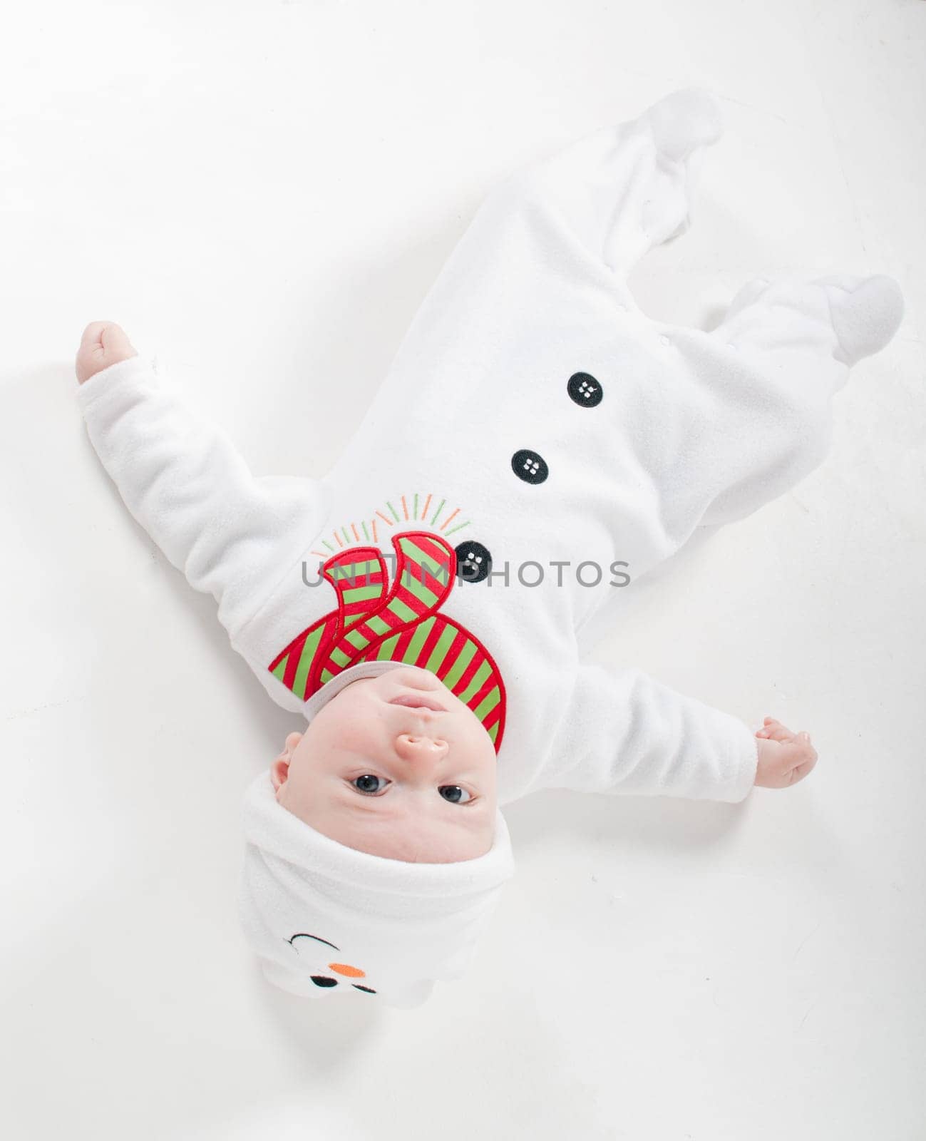 Baby boy in snowman costume  lying on the floor and watching on you