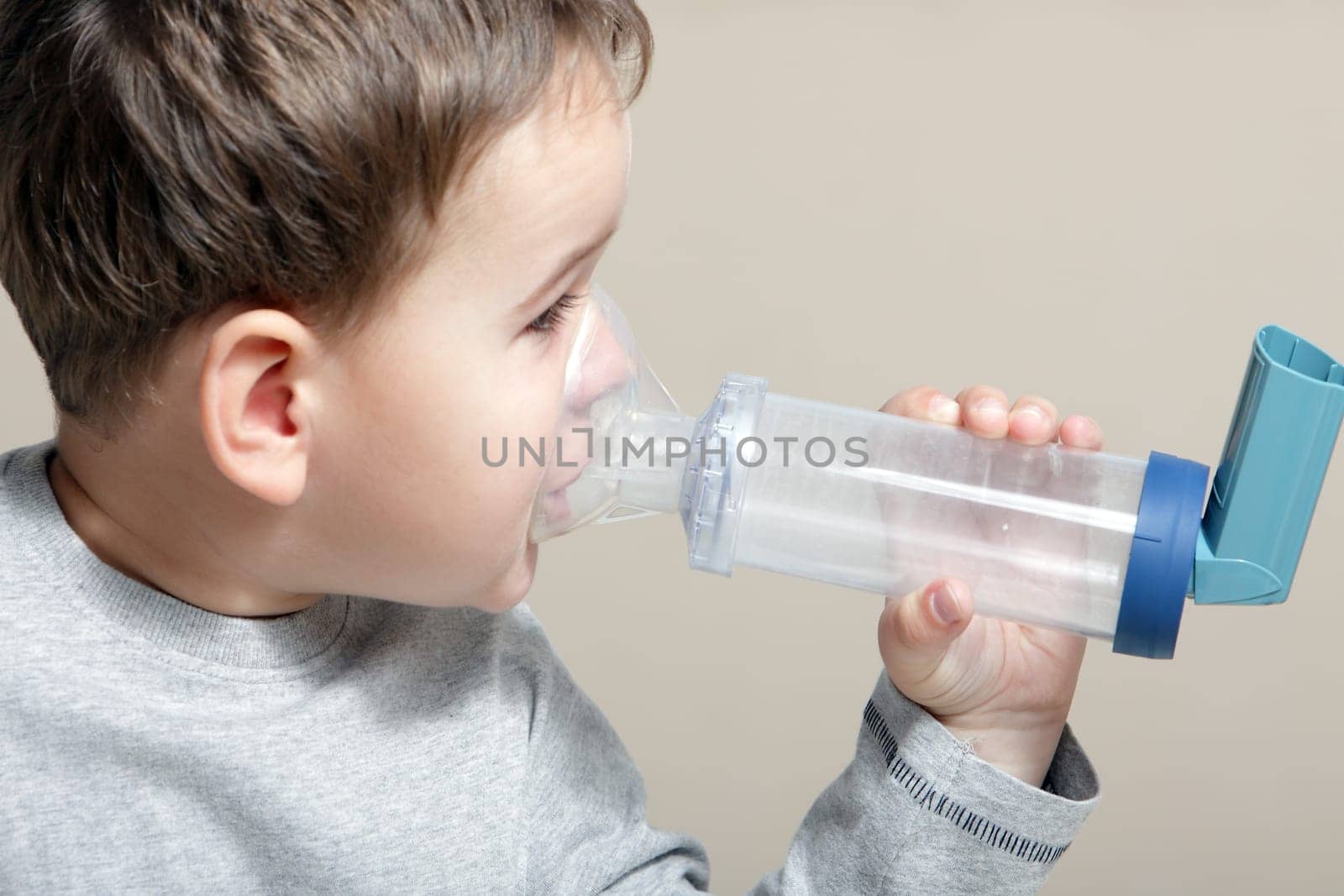 Close-up image little boy using inhaler for asthma.