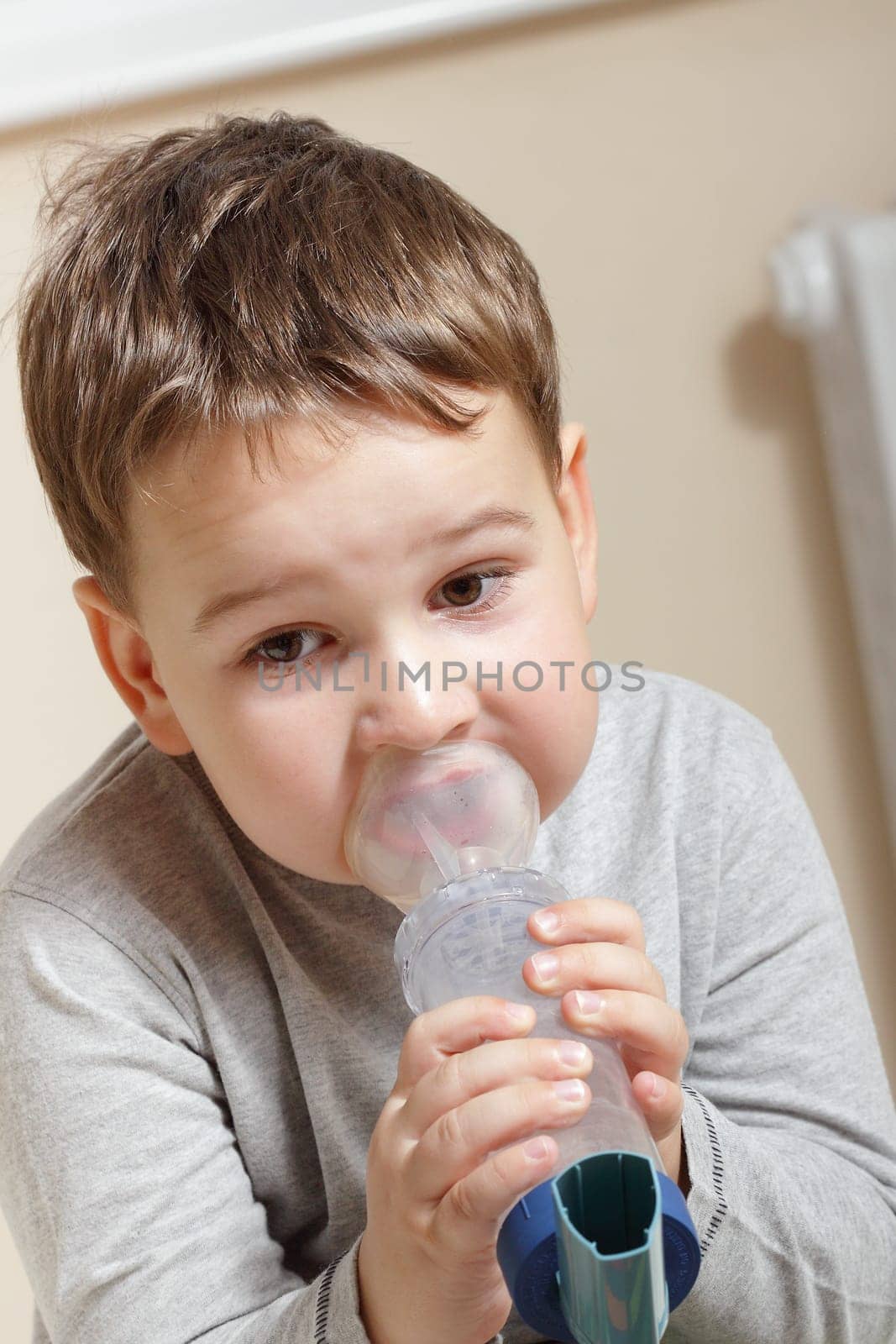 Close-up image little boy using inhaler for asthma.