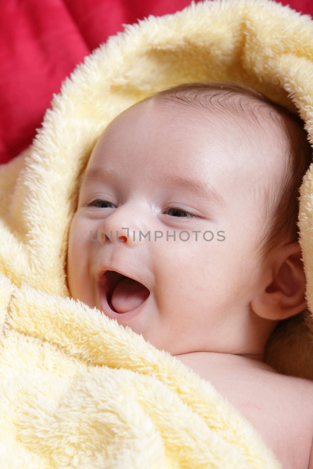Newborn - close-up focus baby boy with yelow blanket with smile