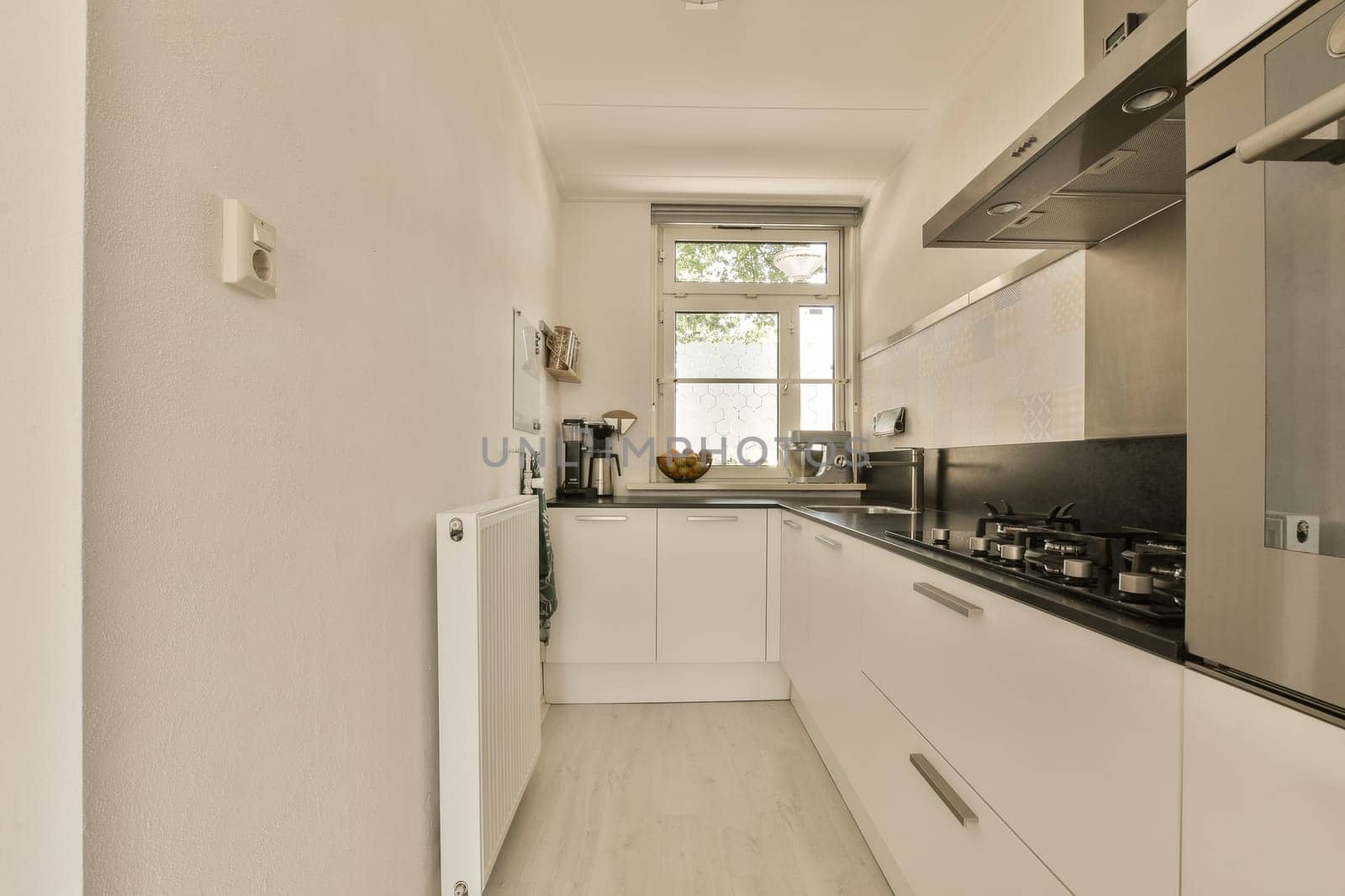 a white kitchen with white cabinets and a window by casamedia