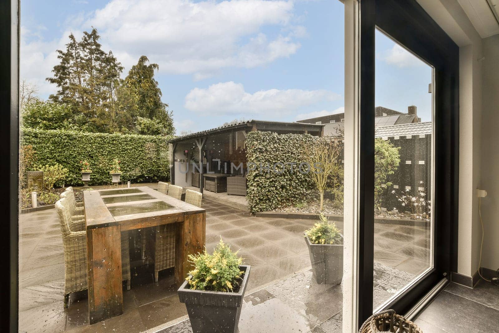 an outside area with pots on the window sies and some plants in pots next to the kitchen sink