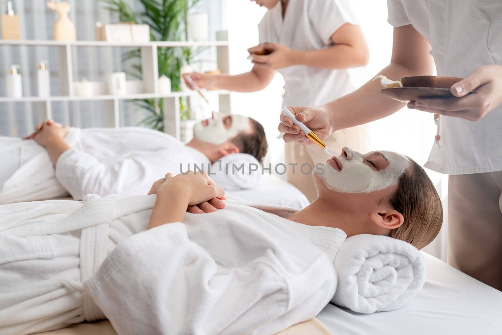 Serene ambiance of spa salon, couple indulges in rejuvenating with luxurious face cream massage with modern daylight. Facial skin treatment and beauty care concept. Quiescent