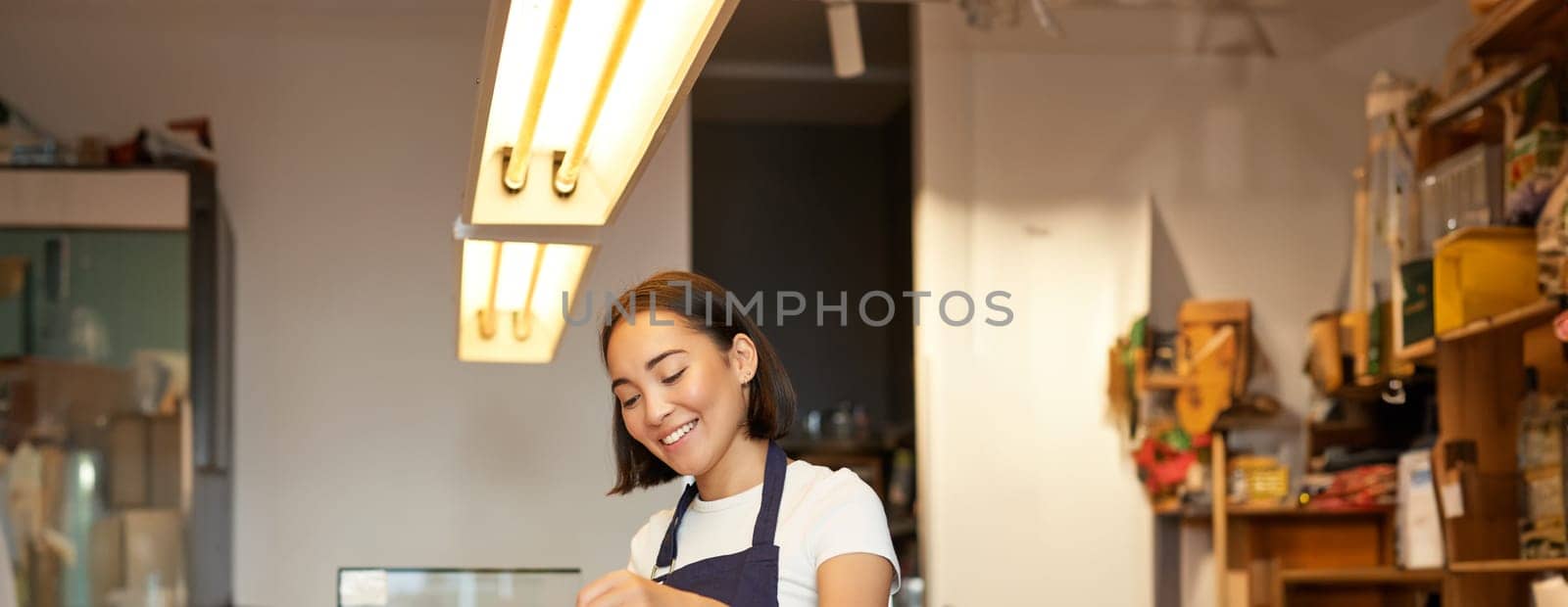 Cute korean barista girl, pouring coffee, prepare filter batch brew pour over, working in cafe. Workplace and people concept