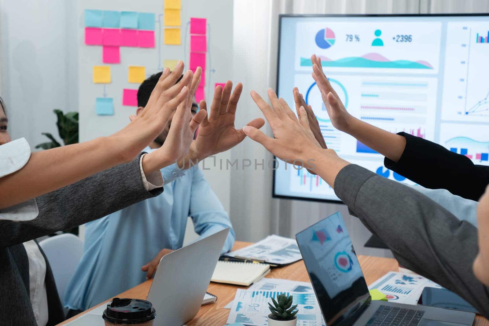 Diverse business team celebrate successful meeting with high-fives and expressions of happiness in corporate office meeting represent unity success and professional integrity. Concord