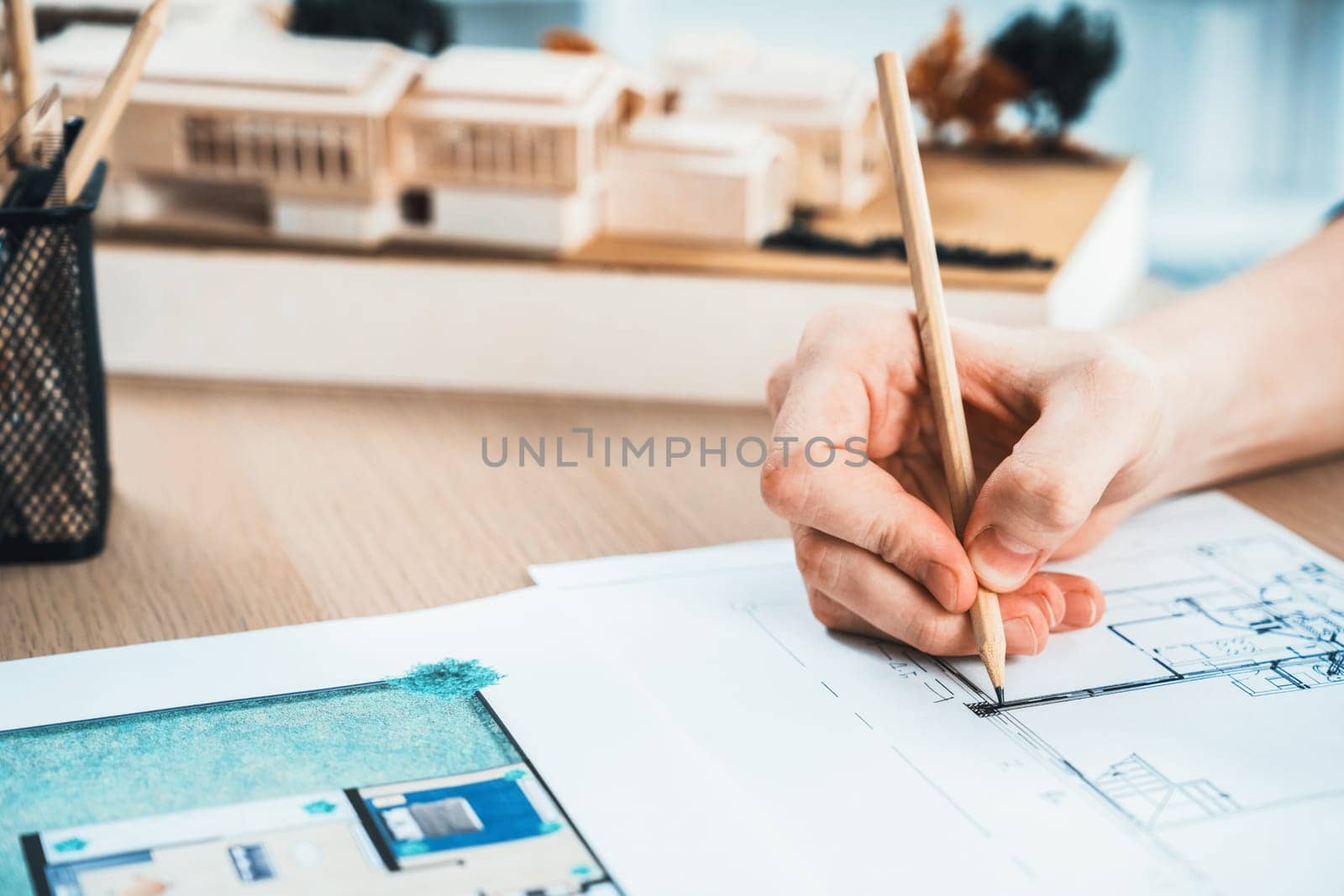 Closeup hand drafting interior house design by architect designer planning home layout on blueprint paper on office desk. Architect carefully draw home interior layout with pencil and tool. Iteration