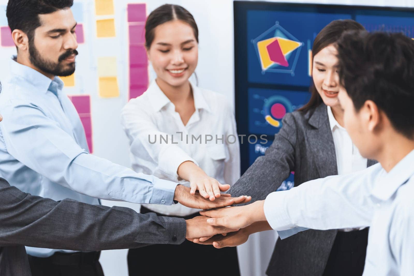 Multiracial office worker's hand stack shows solidarity, teamwork and trust in diverse community. Businesspeople unite for business success through synergy and collaboration by hand stacking. Concord
