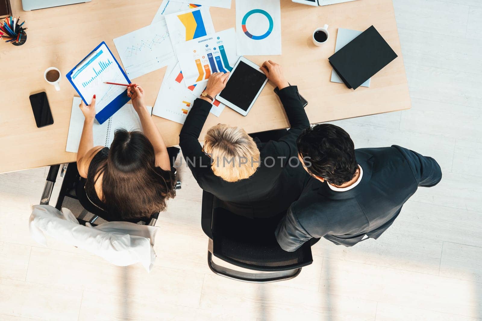 Business people group meeting shot from top view in office . Profession businesswomen, businessmen and office workers working in team conference with project planning document on meeting table . Jivy