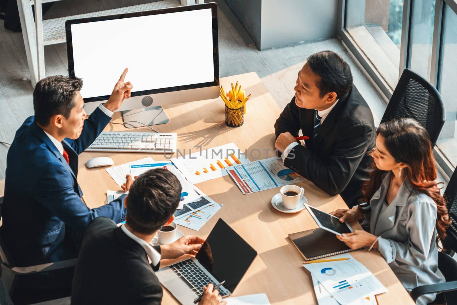 Smart businessman and businesswoman talking discussion in group meeting at office table in a modern office interior. Business collaboration strategic planning and brainstorming of coworkers. Jivy