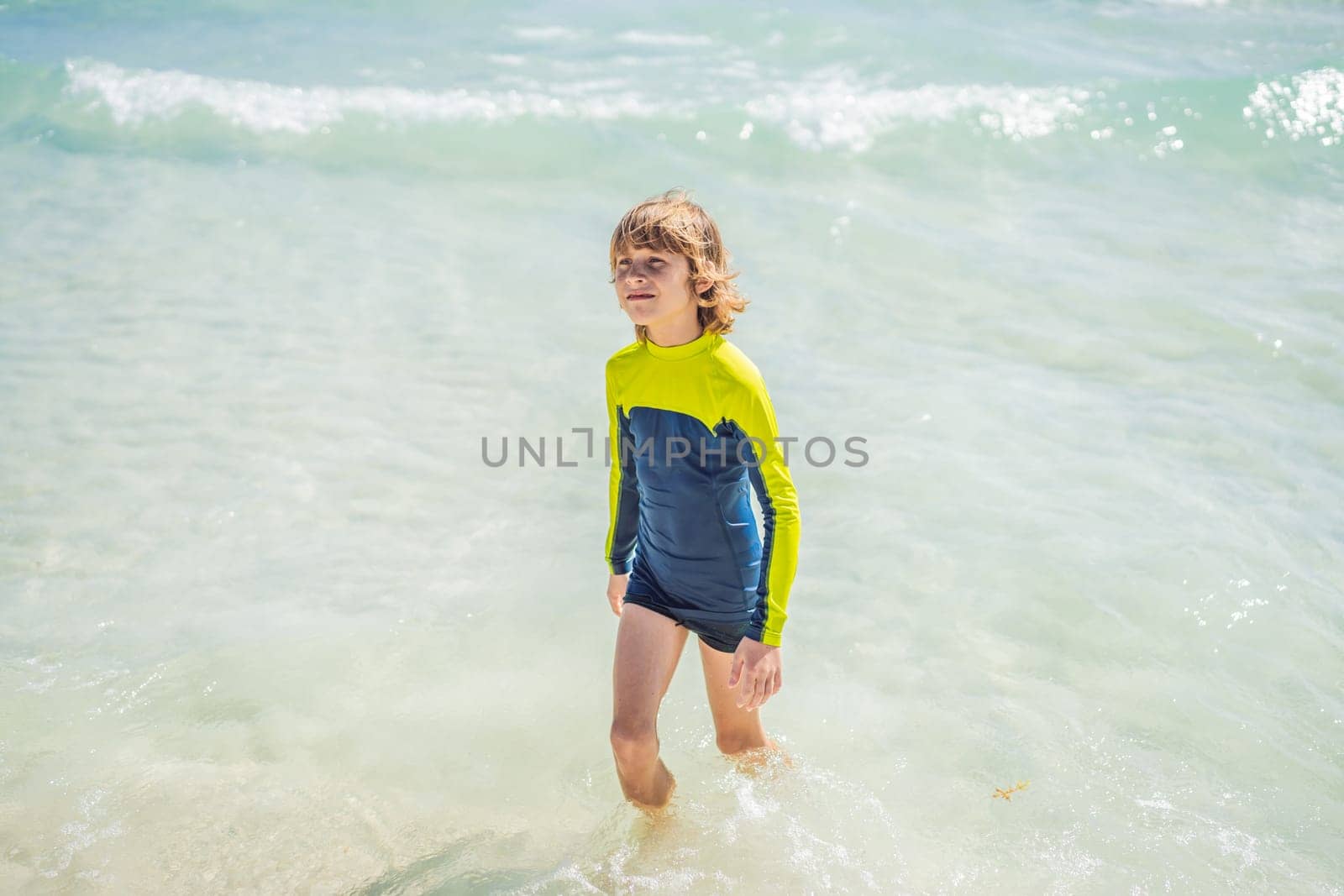 A carefree boy explores the wonders of the beach, with the sun-kissed shoreline as his playground, embodying the spirit of childhood adventure by galitskaya