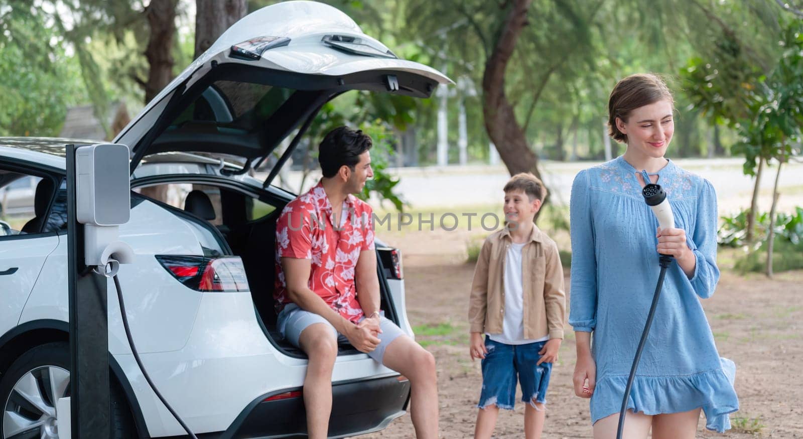 Family road trip vacation with electric vehicle, lovely family recharge EV car with green and clean energy. Natural and eco friendly car travel for sustainable environment. Perpetual