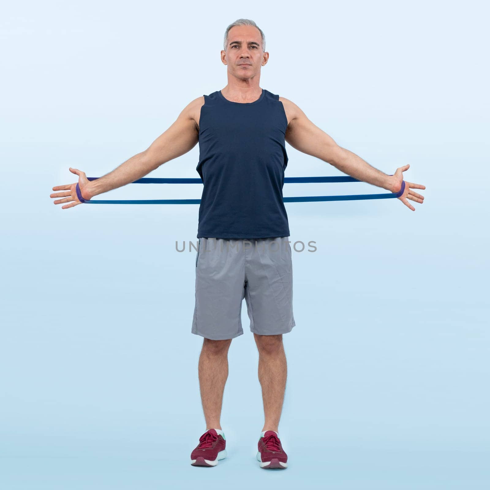 Full body length shot athletic and sporty senior man with resistance band. Clout by biancoblue