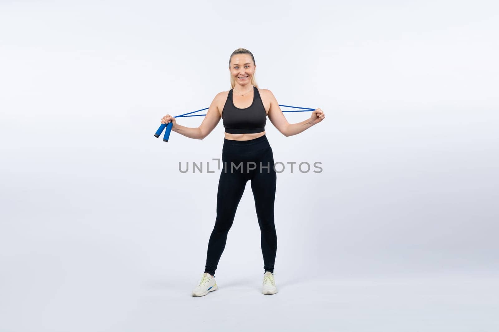 Full body length shot athletic and sporty senior woman with fitness exercising rope on isolated background. Healthy active physique and body care lifestyle senior people. Clout