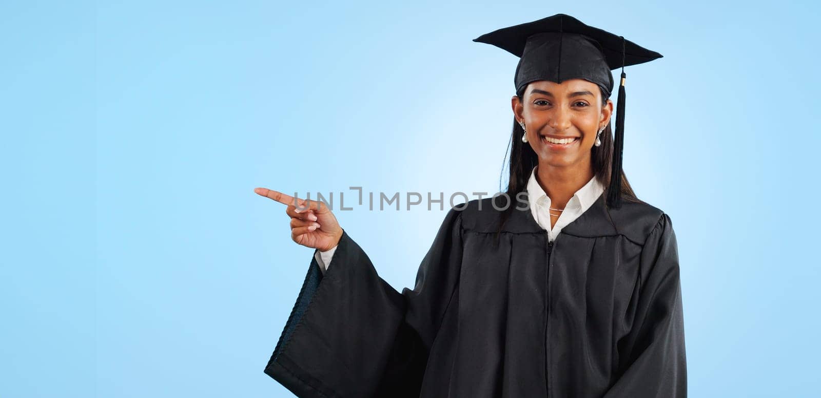 Graduate, studio portrait or happy woman point at school registration, university ads or college information, choice or academy. Mockup space, education and graduation notification on blue background.