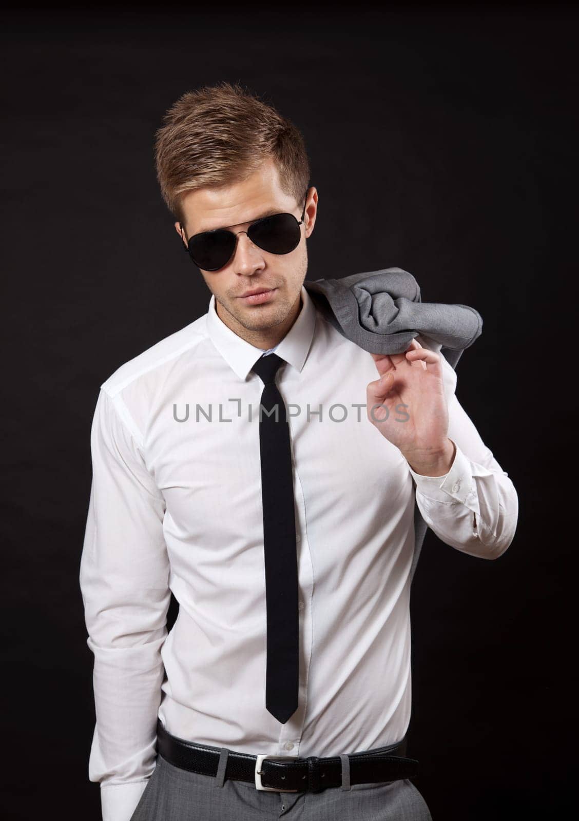 Portrait of a confident businessman wearing sunglasses on dark background