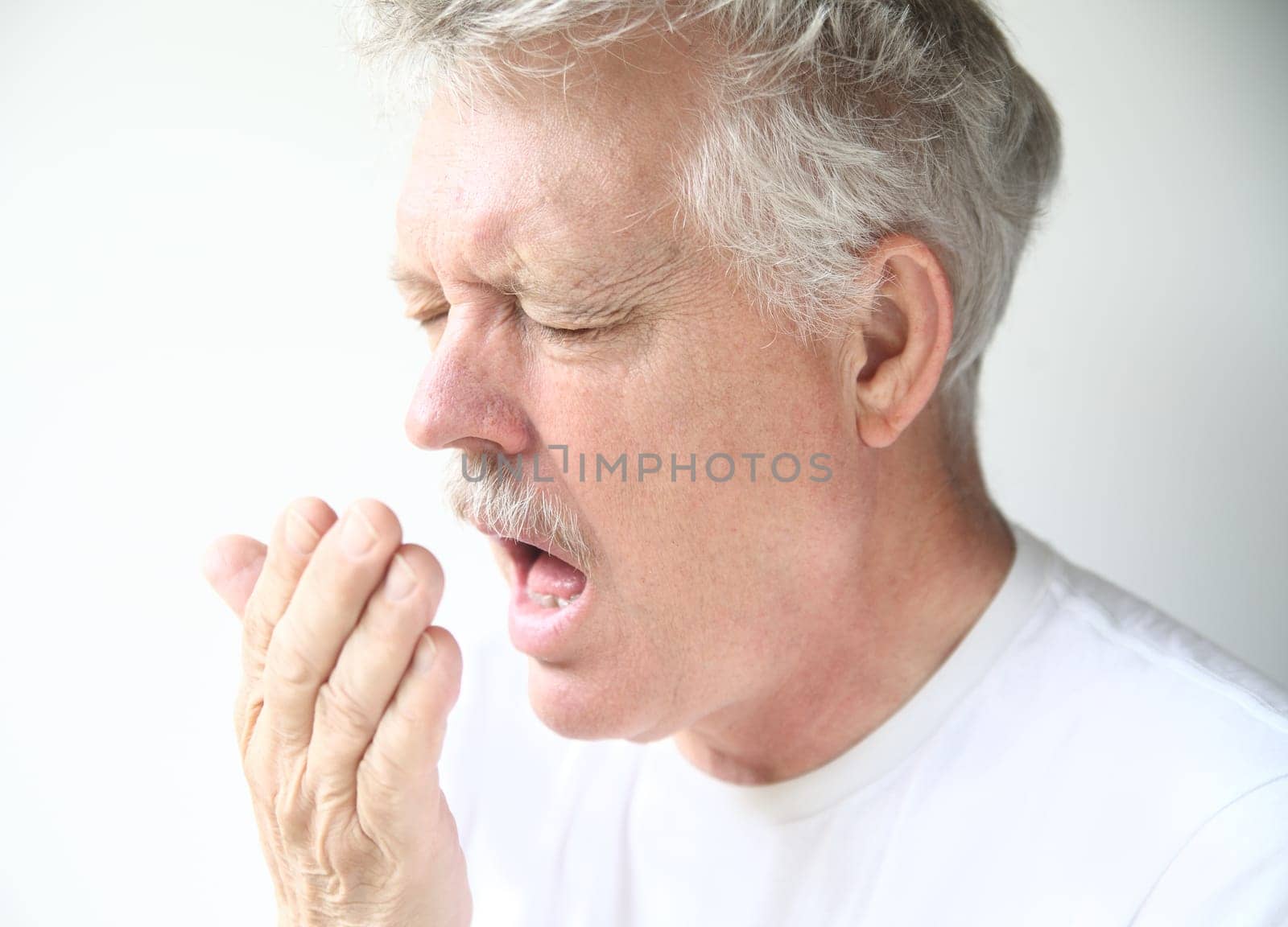 senior man about to sneeze