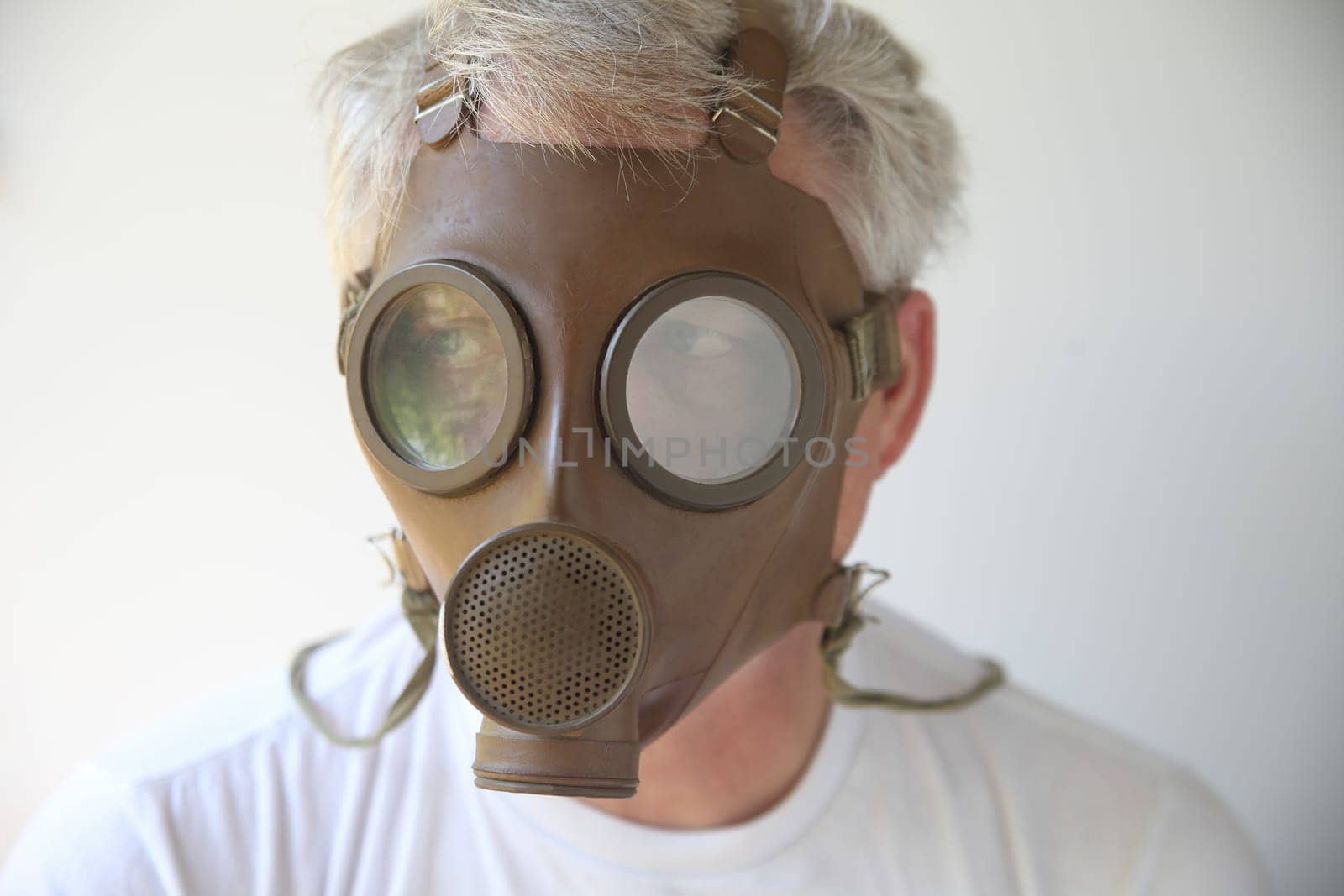 old gas mask worn by senior man