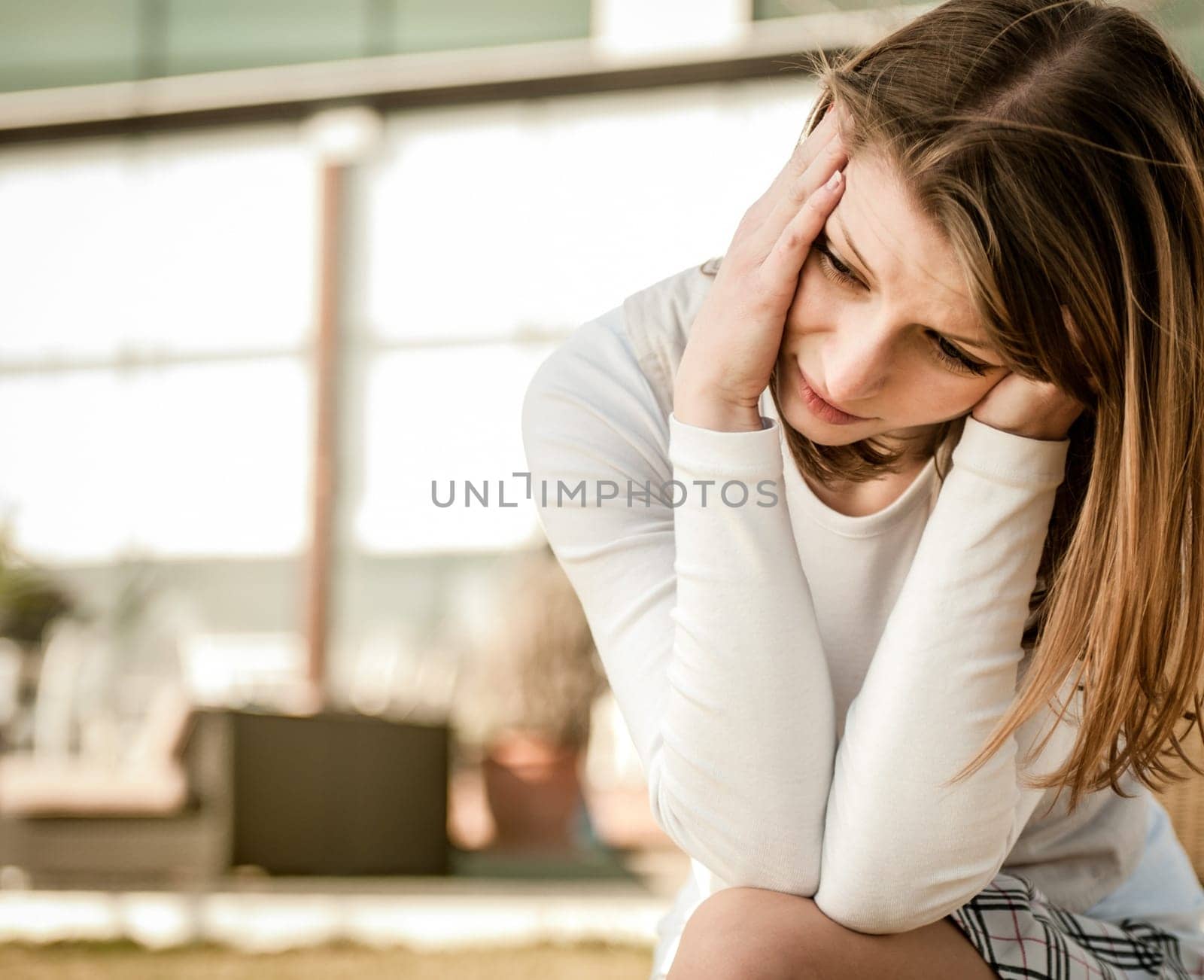Headache - portrait of young woman in pain oudoor - urban setting