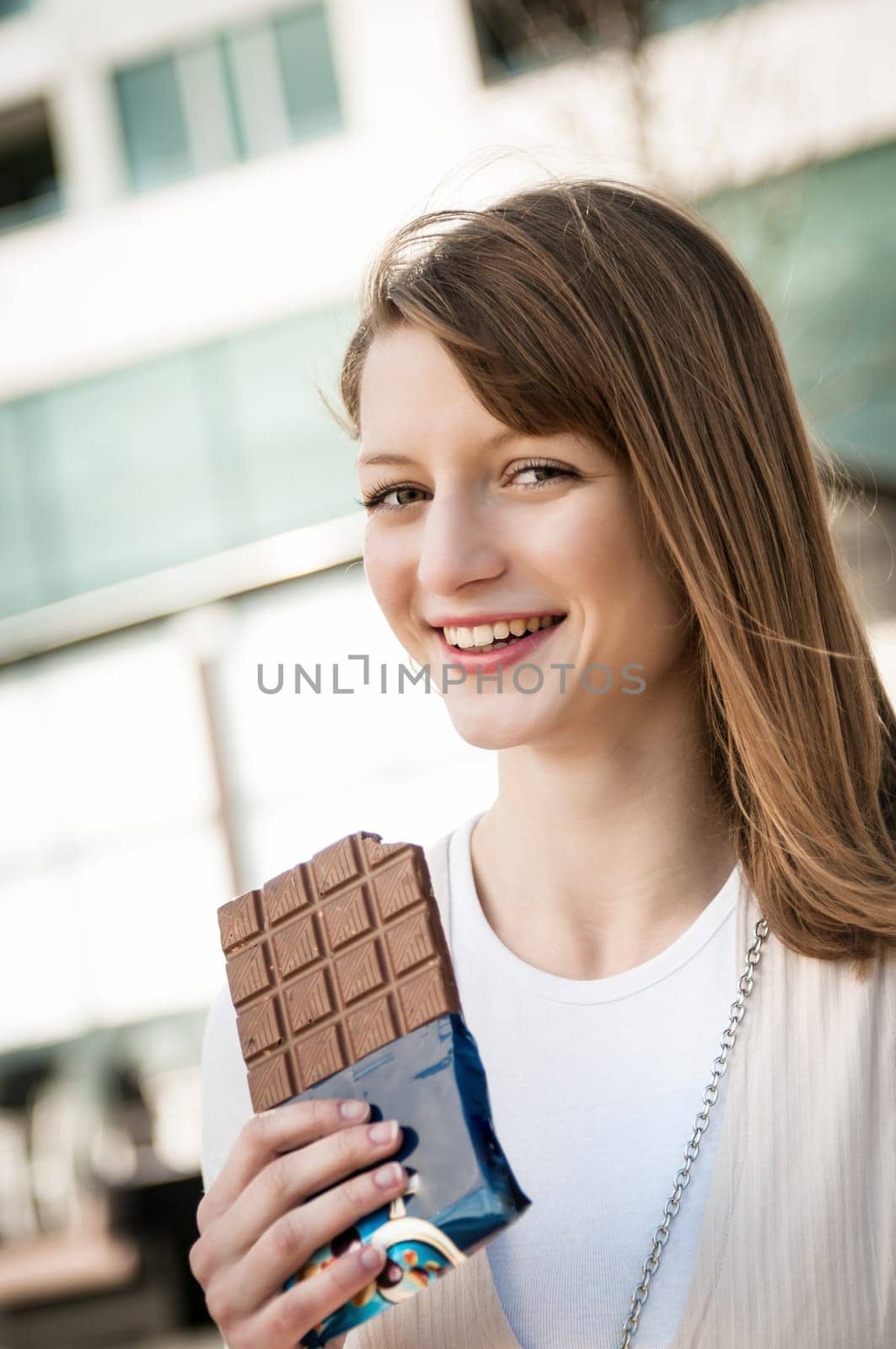 Portrait of young beautiful woman eating chocolate - lifestyle outdoor image