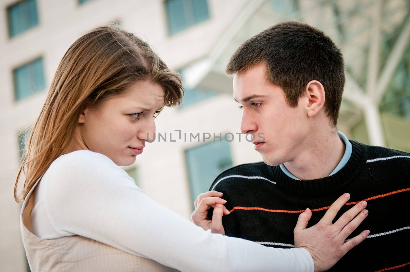 Lifestyle image of young woman refusing man outside on street having relationship problems