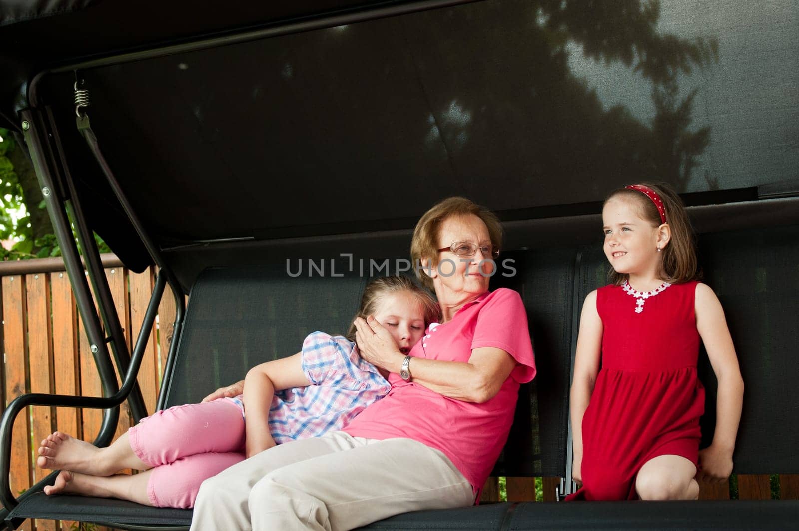 Grandmother with her crandchildren, one is sleeping another with happy expression