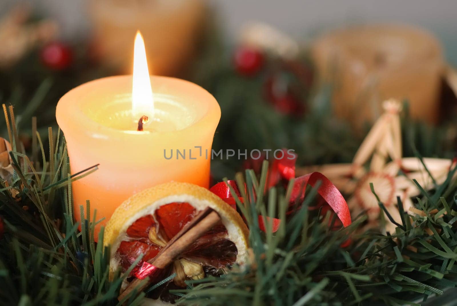 Detail of christmas advent wreath with burning candle. Focus on candle.