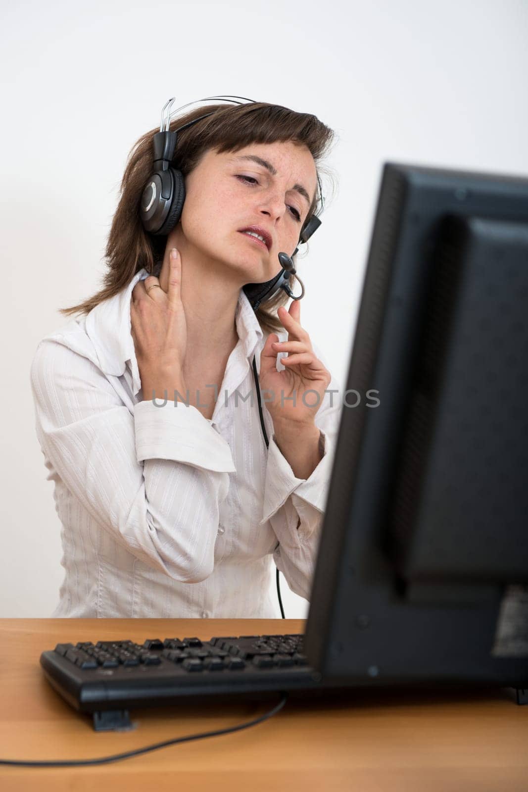 Young business person with neck pain working at computer