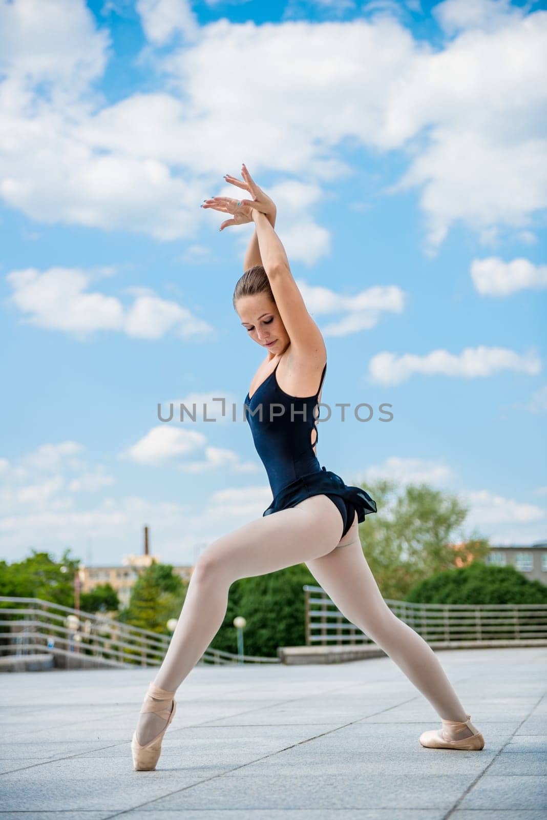 Ballet dancer dancing outdoor with blue sky in background