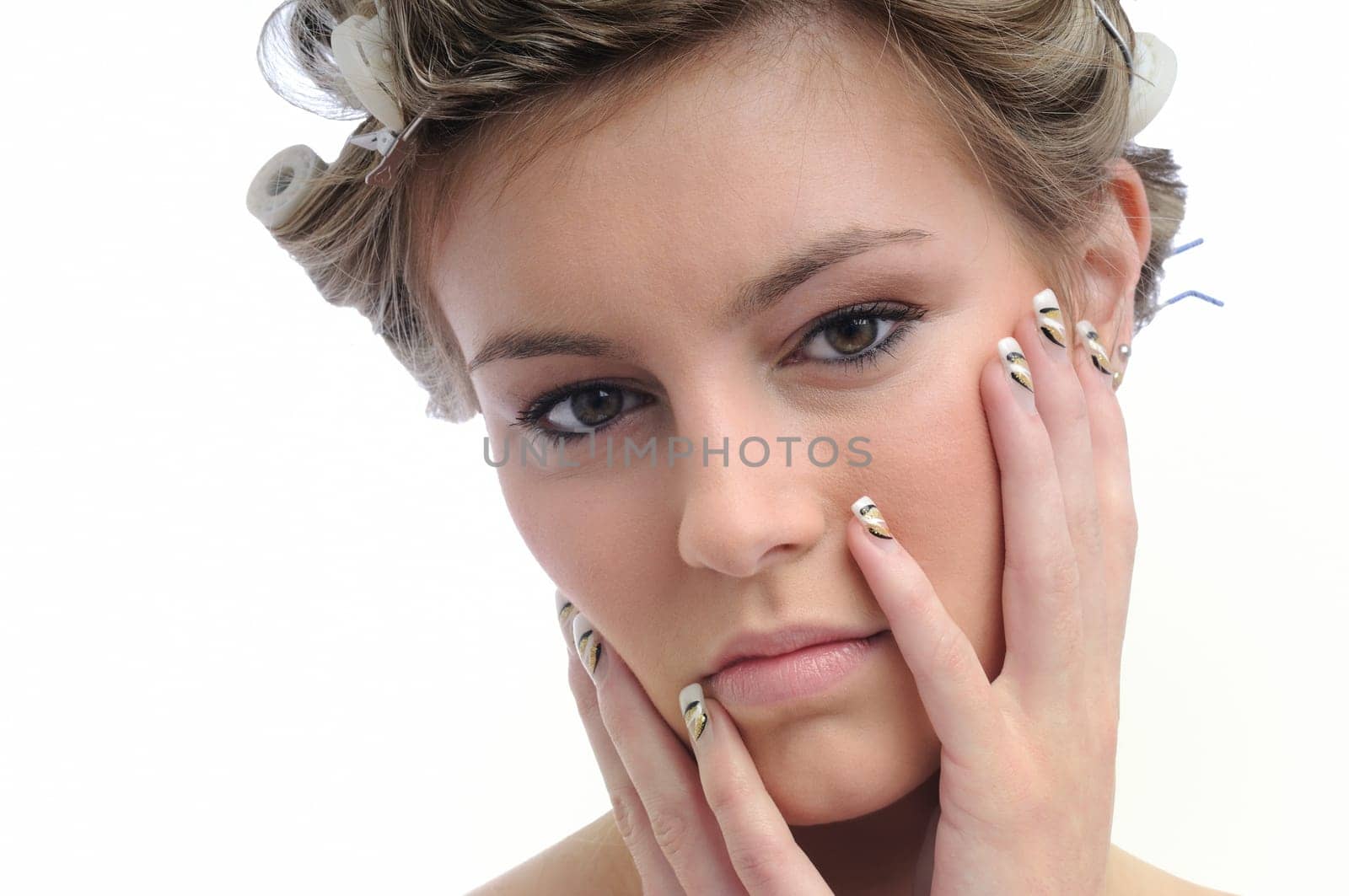 Young beautiful woman with hair rollers in curls isolated on white