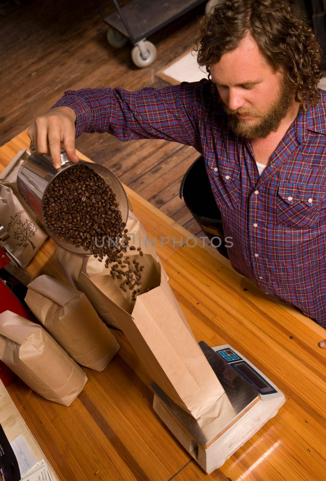 An experienced coffee roaster bags up his finished product.
