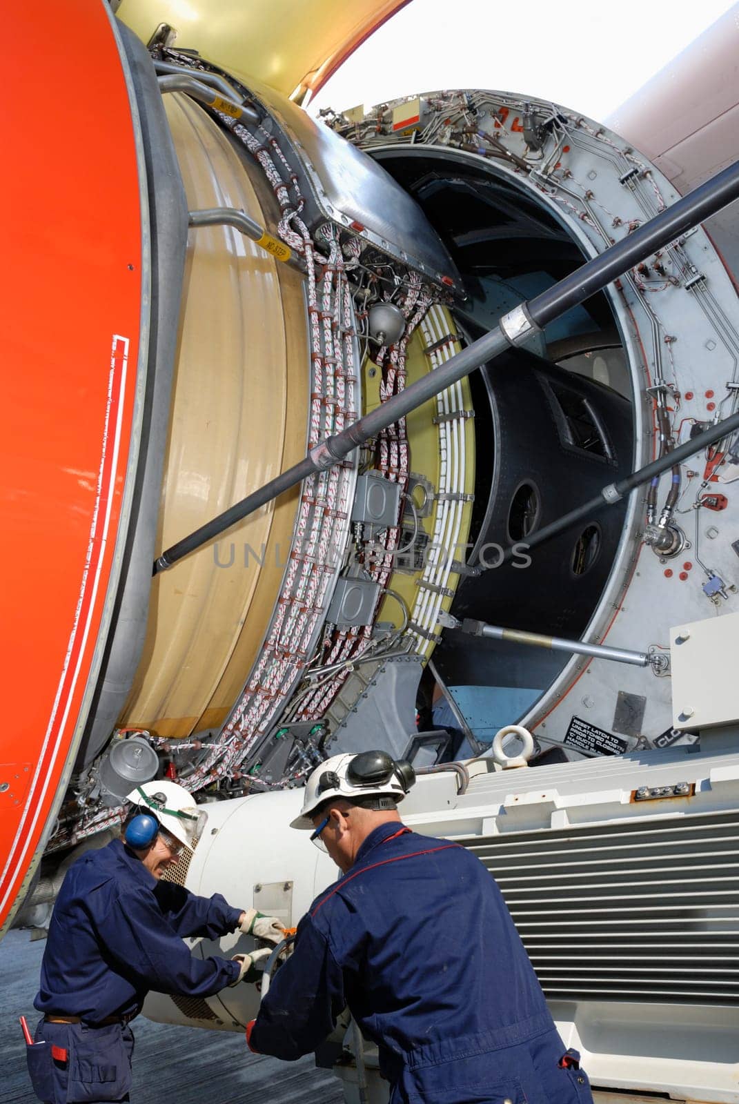 two airplane-mechanics working and calibrating a jet-engine