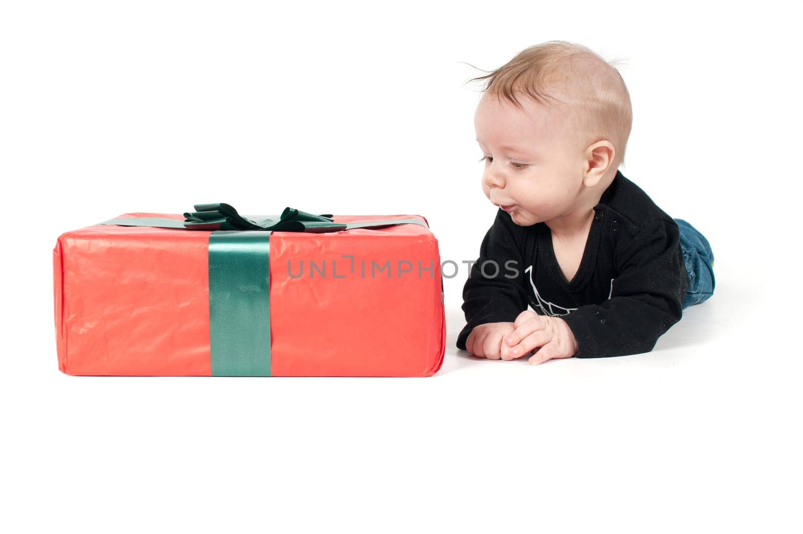 Beautiful baby boy and big christmas present on white