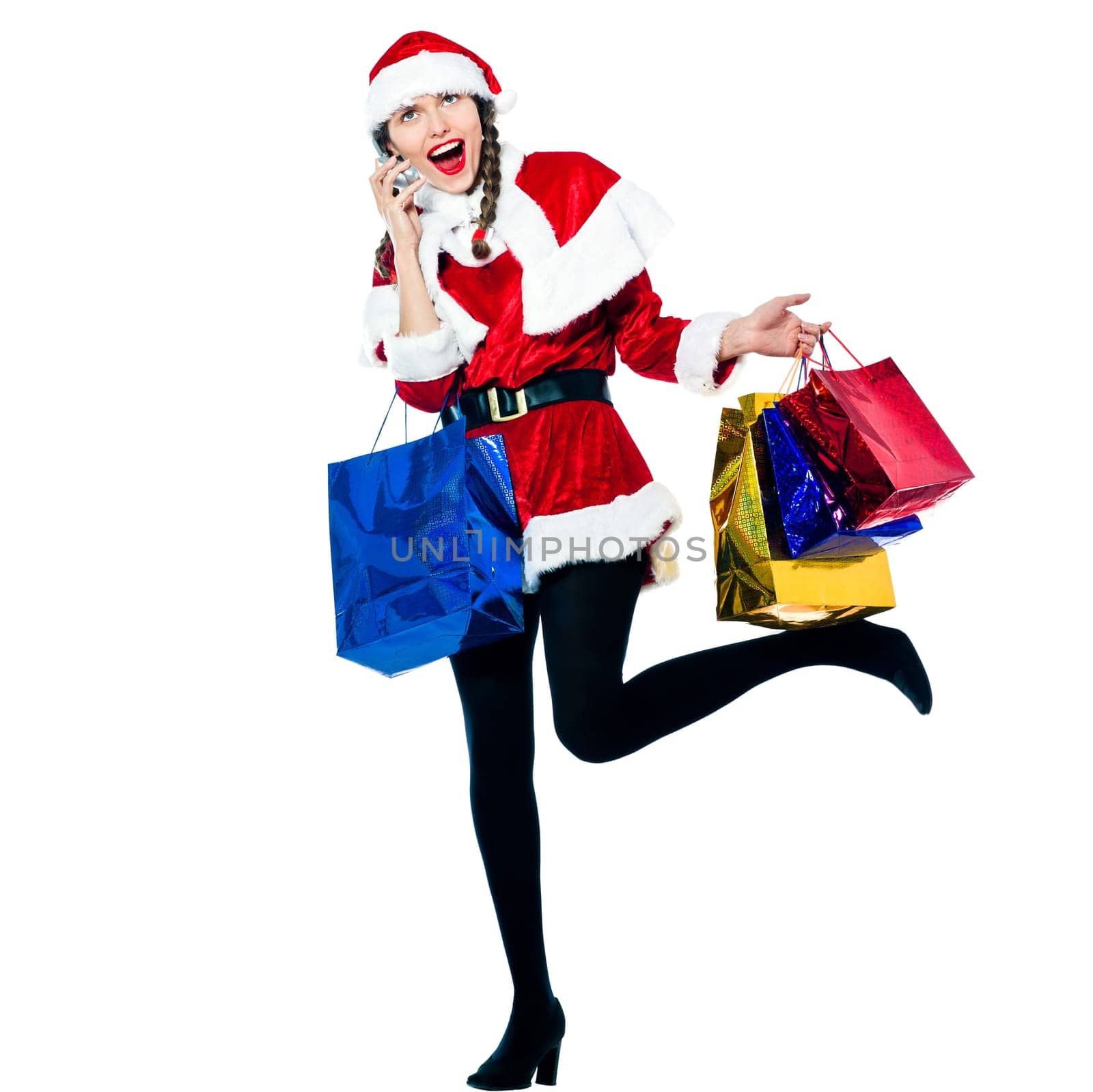 one happy woman dressed as santa claus carrying on the telephone christmas bags  on studio isolated white background