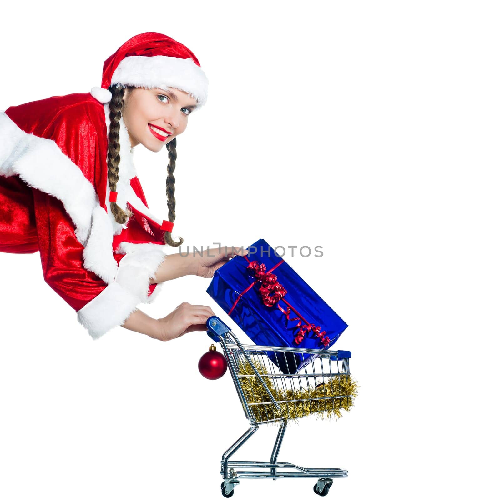 one woman dressed as santa claus holding presents gifts with christmas shopping cart on studio isolated white background