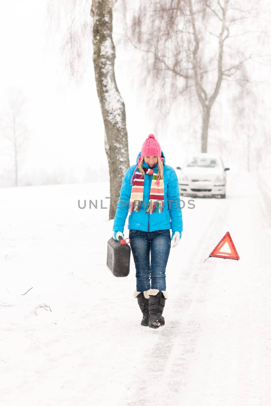 Woman carrying gas can snow car trouble winter breakdown walking