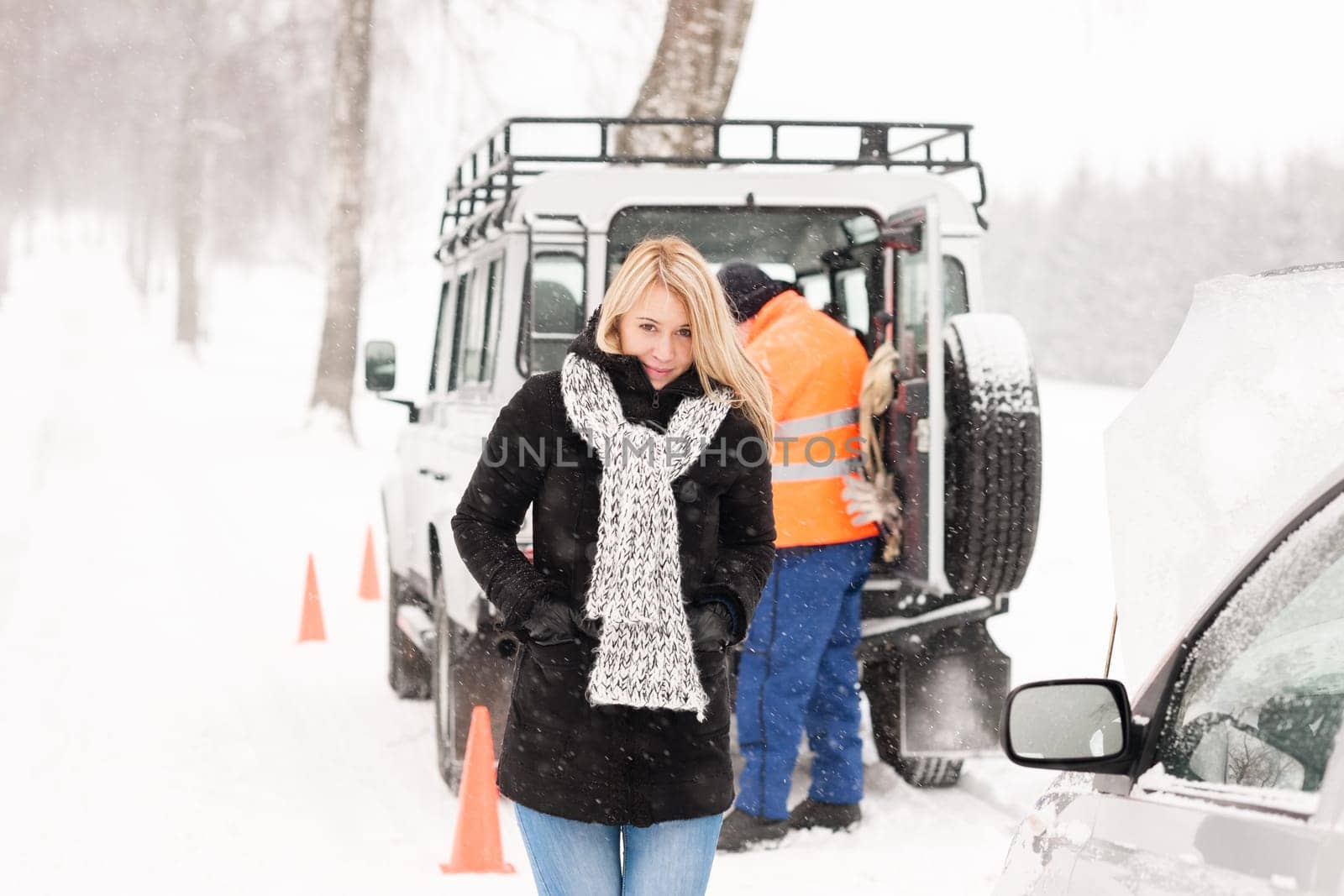 Mechanic helping woman with broken car snow assistance road winter