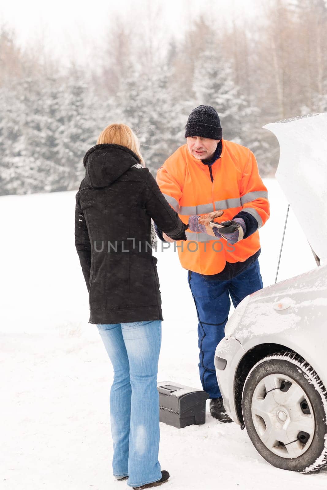 Woman handshake mechanic broken car snow help assistance winter man