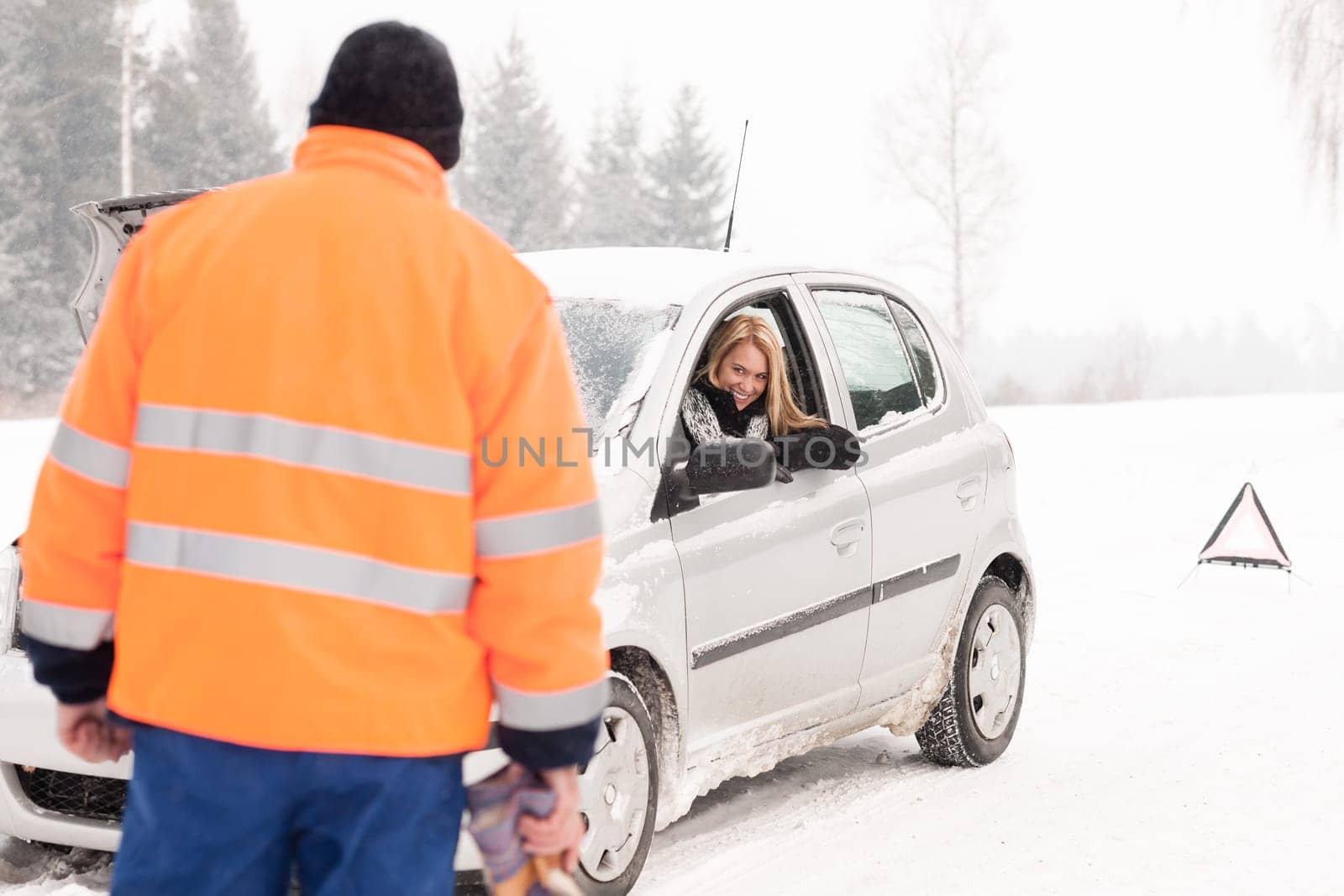 Man helping woman car breakdown assistance snow happy broken winter