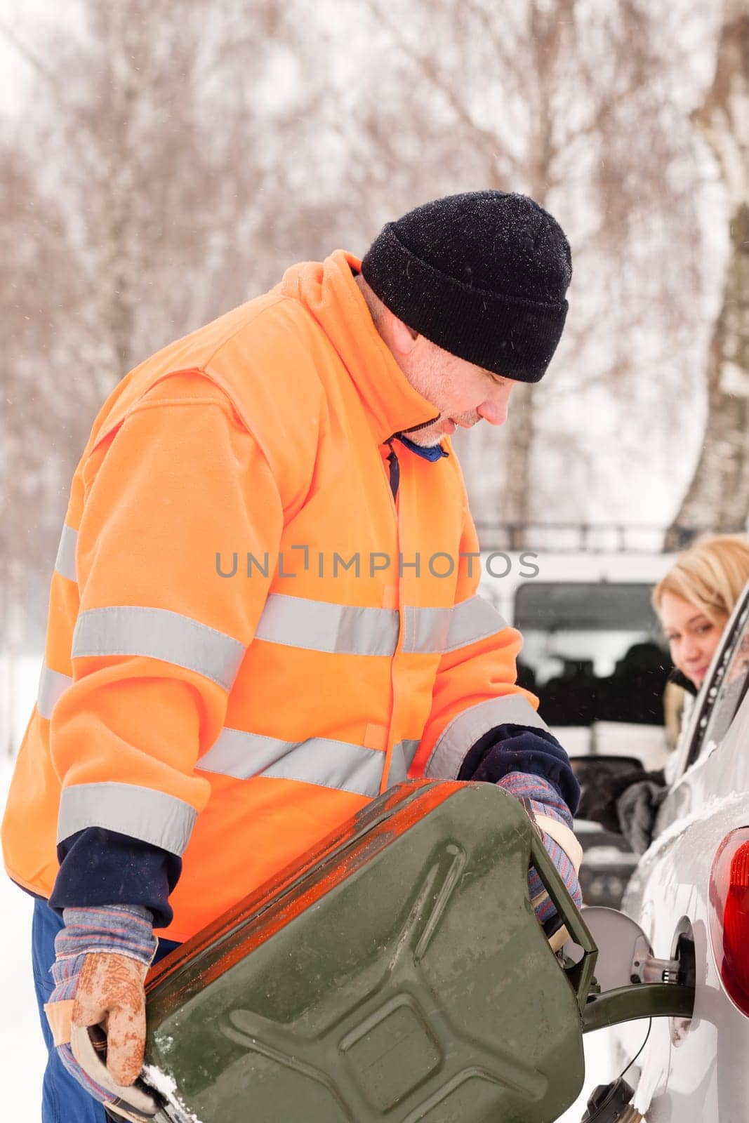 Man filling woman car gas snow assistance winter breakdown help
