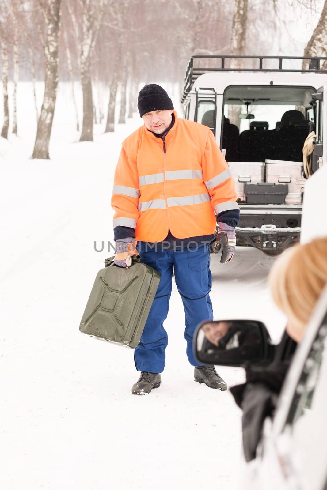 Woman broken car man gas can snow assistance winter mechanic
