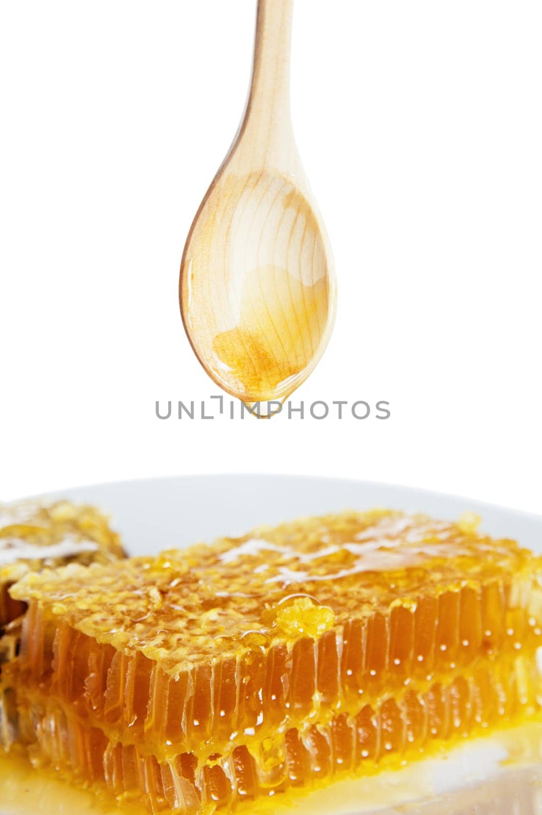 spoon with honeycomb  on white plate