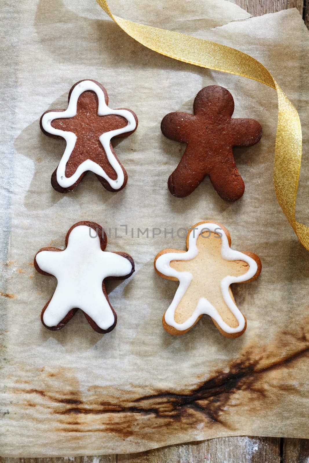 4 Gingerbread men on a grunge baking paper for christmas food and cookie concept