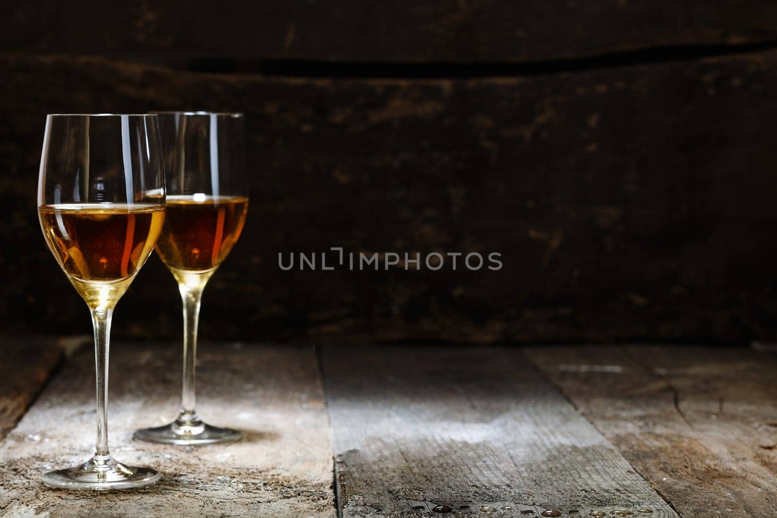 Two glasses of sherry on brown wooden background with copyspace