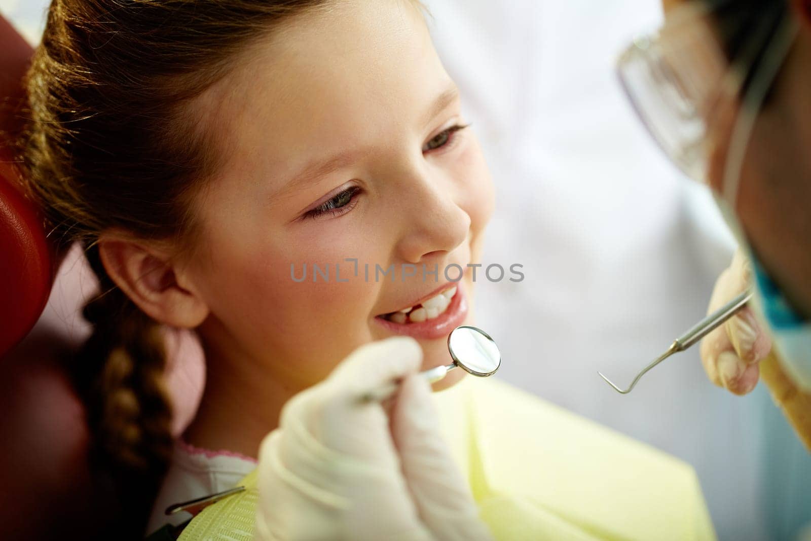 Close up portrait of a little smiling girl at dentists office