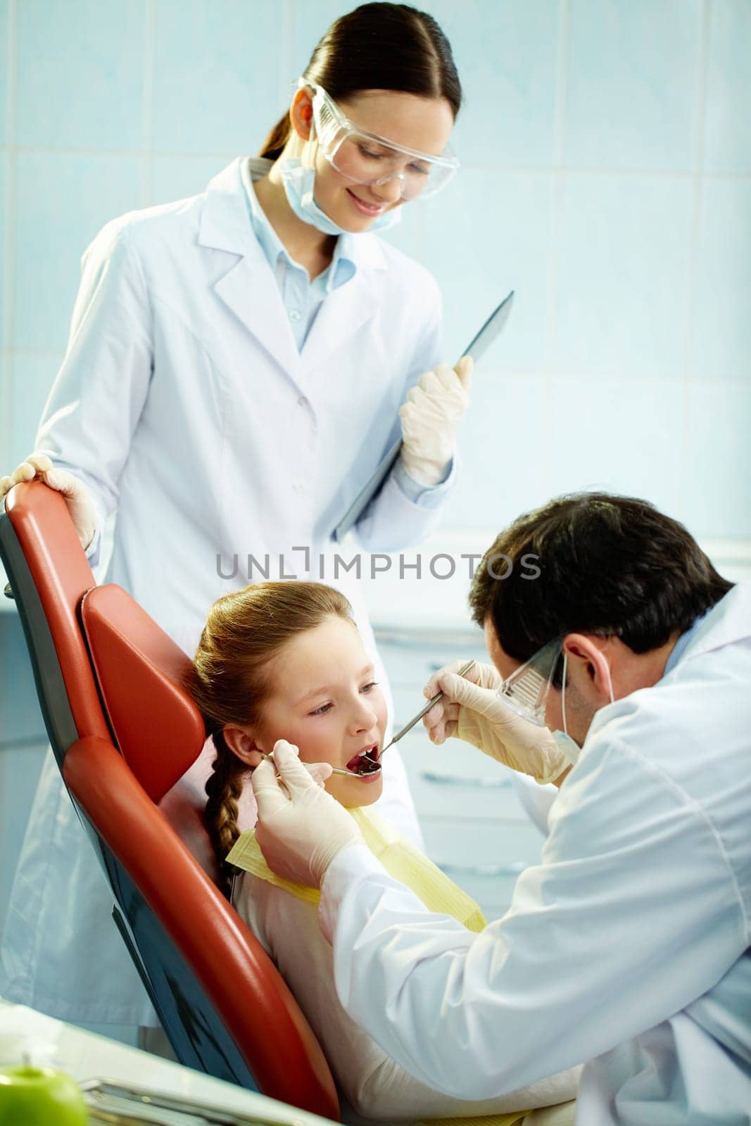 Young patient undergoing usual check-up procedure at dentists
