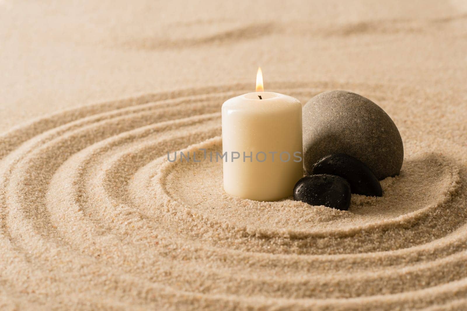 Spa atmosphere candle with zen stones in sand still nature